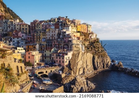 Beautiful view of rocky hills and colorful historic buildings of Manarola, tourist attraction and famous place in Liguria, Italy. Hillside over the sea at sunset. Foto d'archivio © 