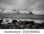 Beautiful view of the rocky shore of the ocean, the waves of which crash against the rocks