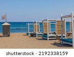 Beautiful view of sand beach on sea coastline with comfortable sun beds for hotel tourists. Rhodes. Greece.