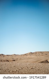 A Beautiful View Of The Sandy Hills In The Desert Under The Blue Sky