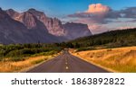 Beautiful View of Scenic Highway with American Rocky Mountain Landscape in the background. Colorful Summer Sunrise Sky. Taken in St Mary, Montana, United States.