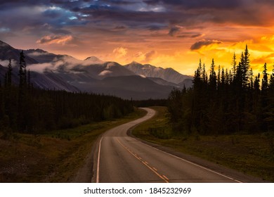 Beautiful View of a scenic road, Alaska Hwy, in the Northern Rockies during a sunny and cloudy morning sunrise. Dramatic Sky Artistic Render. Taken in British Columbia, Canada. Nature Background