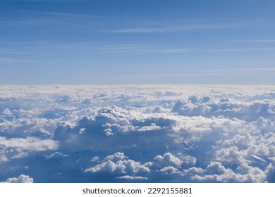 A beautiful view of the sky, clouds and icebergs seen from inside the plane.