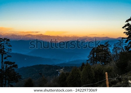 Beautiful view of snow capped mountains at twilight surrounded by mist