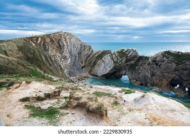 Beautiful view of Stair Hole, small cove to the west of Lulworth Cove in Dorset, Untited Kingdom. View of rock formations and nature made caves and blue sea, selective focus