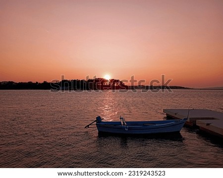 Beautiful view of sunset on the coast with stone peer and wooden boat
