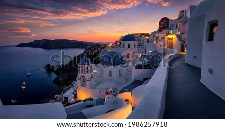 Beautiful view to the three blue domed churches in the village of Oia, Santorini, Greece, during dusk without people