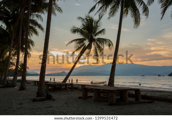 The beautiful view of the\
twilight and Human Interest of the Holtekamp Beach, Papua,\
Indonesia