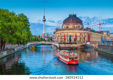 Beautiful view of UNESCO World Heritage Site Museumsinsel (Museum Island) with excursion boat on Spree river and famous TV tower in the background in beautiful evening light at sunset, Berlin, Germany