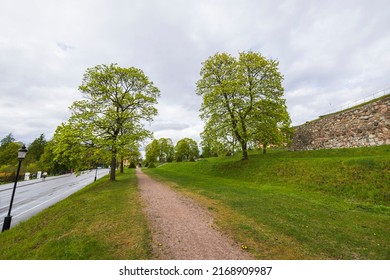 Beautiful view in Uppsala city downtown with high stone wall, trees and highway. Sweden.