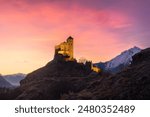 A beautiful view of the Valere Basilica in Sion at sunset with pink and orange colors