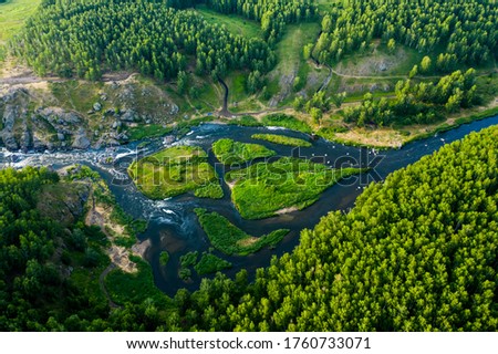 beautiful view vertically down from a great height on beautiful valley with forest and rocks, the mountain river is divided into several streams and Islands. Ural, the threshold Revun.
