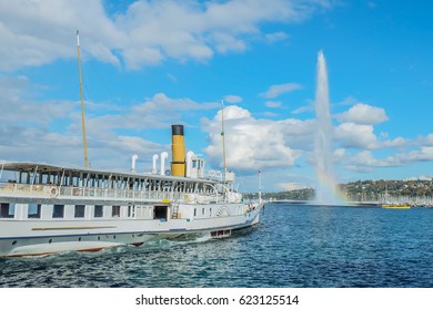 Beautiful view of the water jet fountain with rainbow in the lake of Geneva and the cityscape of Geneva at sunset, Switzerland
