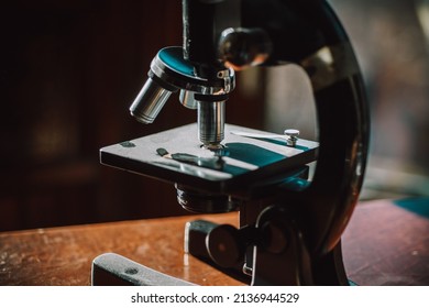 Beautiful vintage antique microscope and compass shot in dramatic sunlight with dark shadows and bright warm highlights