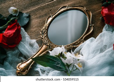 Beautiful a vintage mirror with flowers on wooden background