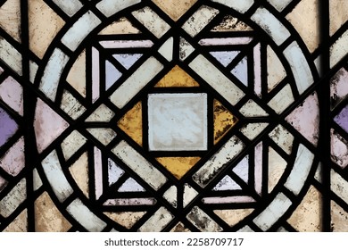Beautiful vintage stained glass window with a geometric pattern and frame.
