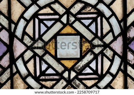 Beautiful vintage stained glass window with a geometric pattern and frame.