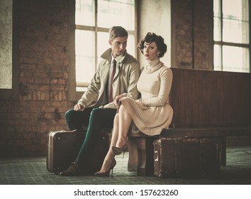 Beautiful vintage style young couple with suitcases on a train station - Powered by Shutterstock