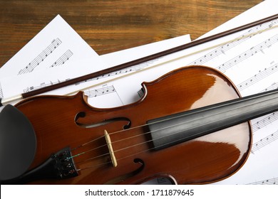 Schöne Geige, Bogen- und Notenblätter auf Holztisch, flach