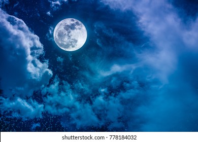 Beautiful vivid cloudscape with many stars. Night sky with bright full moon and cloudy, serenity blue nature background. Outdoor at nighttime with moonlight.