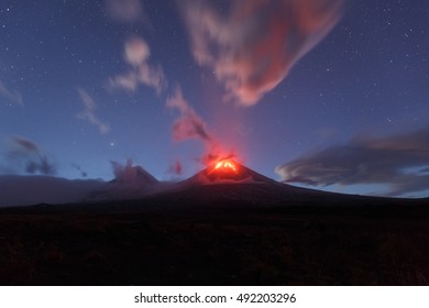 Beautiful volcanic erupting landscape of Kamchatka: night view of red hot lava flows eruption active volcano Klyuchevskaya Sopka. Russian Far East, Kamchatka Peninsula Klyuchevskaya Group of Volcanoes