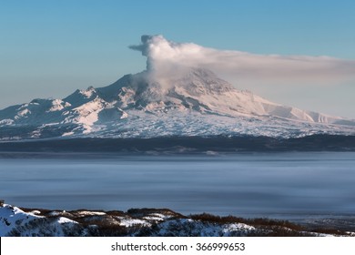 Beautiful volcanic landscape of Kamchatka Peninsula: eruption active Shiveluch Volcano - emission from crater of volcano plume of gas, steam and ashes. View of volcano at sunrise. Russian Far East.