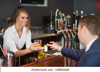 Beautiful waitress serving handsome businessman in a classy bar - Powered by Shutterstock