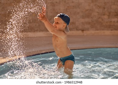 Beautiful Water Explosion. Caucasian Cute Toddler Swims And Have Fun In Small Pool For Swimming. Concept Of Summer Vacations And Fun. High Quality Photo. Copy Space