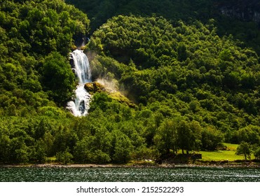 Beautiful Waterfall Between Green Trees On Nærøyfjord In Early Summer In Norway