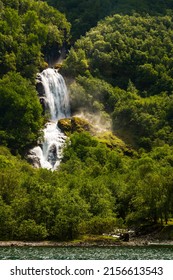 Beautiful Waterfall Between Green Trees On Nærøyfjord In Early Summer In Norway