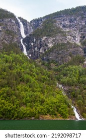 Beautiful Waterfall Between Green Trees On Nærøyfjord In Early Summer In Norway