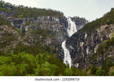 Beautiful Waterfall Between Green Trees On Nærøyfjord In Early Summer In Norway