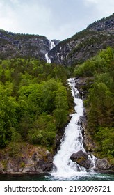 Beautiful Waterfall Between Green Trees On Nærøyfjord In Early Summer In Norway