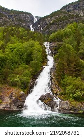 Beautiful Waterfall Between Green Trees On Nærøyfjord In Early Summer In Norway