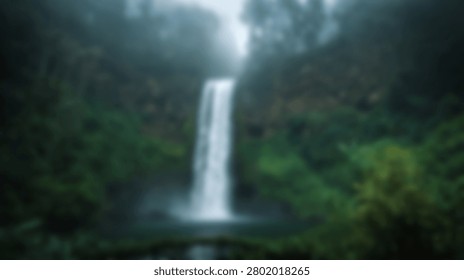 A beautiful waterfall flows into a pool surrounded by dense green jungle foliage and mist