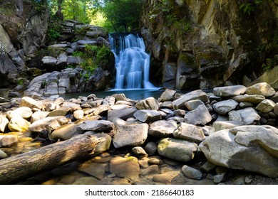 Beautiful Waterfall In The Mountain's Forest With Some Rocks In Front Of It. Long Exposure. No People, Daylight.