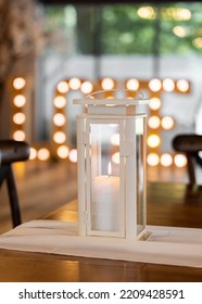 Beautiful Wax Real Candle Burning In Romantic Wedding Venue Setting With Love Letters Illuminated Out Of Focus Behind.