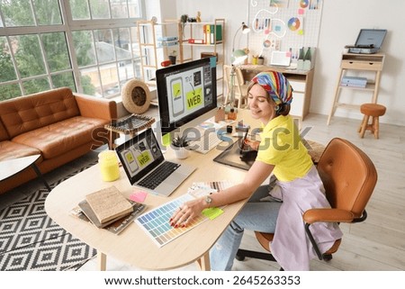 Beautiful web designer working at table in office