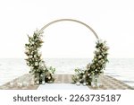 beautiful wedding arch on the pier overlooking the sea. modern round wedding arch with candles and flowers. Wedding decorations