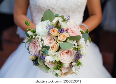 Beautiful wedding bouquet in hands of the bride. Rose, cotton, roses. Pink, white and Peach. Trendy and modern wedding flowers. Soft pastels.