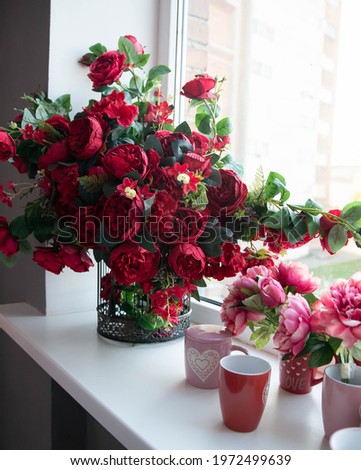 Woman decorated large bouquet of flowers with roses in vase