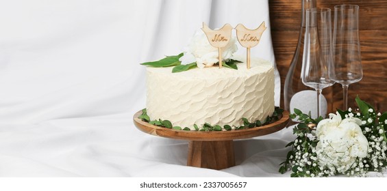 Beautiful wedding cake with champagne glasses on flowers on table - Powered by Shutterstock