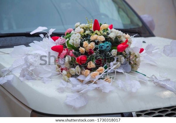 Beautiful\
wedding car. Front of the luxury car decorated flowers . Decorated\
with flowers as for a wedding . Fresh flowers on the car. Beautiful\
colorfull wedding bouquet on white wedding\
car