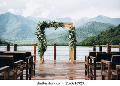 Beautiful wedding ceremony place on the lake in rustic style with natural materials