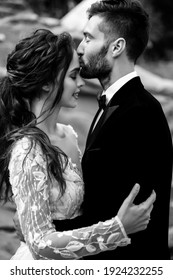 Beautiful Wedding Couple Laugh And Kiss On The Background Of Stones. High Quality Photo