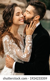 Beautiful wedding couple laugh and kiss on the background of stones. High quality photo