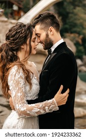 Beautiful Wedding Couple Laugh And Kiss On The Background Of Stones. High Quality Photo