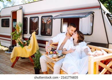 Beautiful Wedding Couple Laugh And Kiss Relaxing In Rv, Camping In A Trailer. Romantic Moment. Together. Wedding. Marriage.