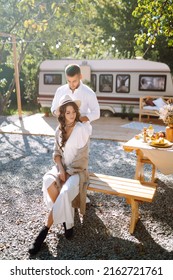 Beautiful Wedding Couple Laugh And Kiss Relaxing In Rv, Camping In A Trailer. Romantic Moment. Together. Wedding. Marriage.