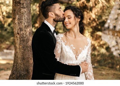 Beautiful wedding couple of newlyweds hugging on the background of the forest.